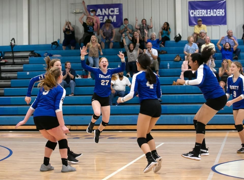 female volleyball players celebrating a win.